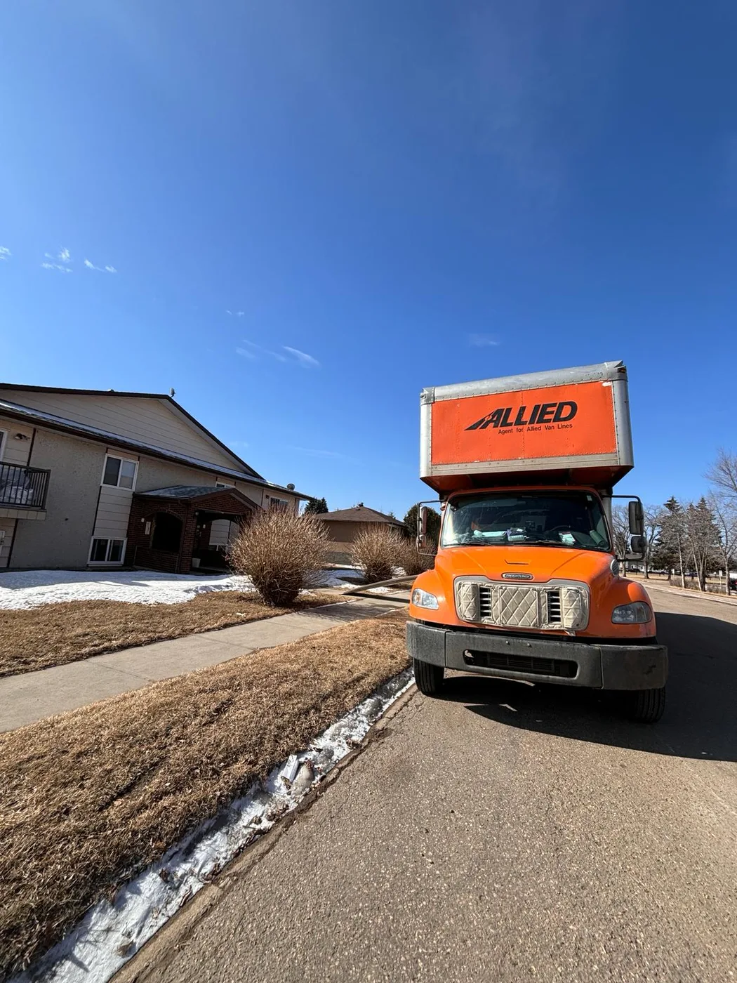 Allied Van Lines moving truck parked beside a home.