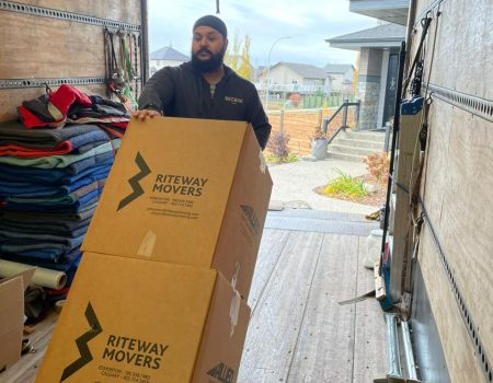 Riteway mover carrying a branded box from the moving truck