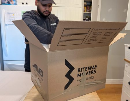 Riteway mover packing household belongings in a branded box