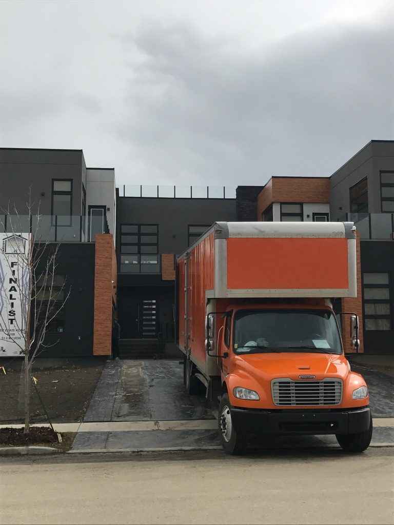 Riteway Allied moving truck outside a modern Chestermere home