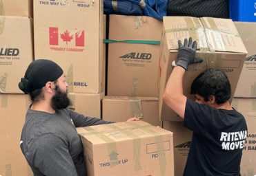 Riteway movers carrying boxes together during a home move