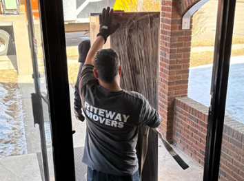 Riteway mover carefully moving furniture through a home entrance